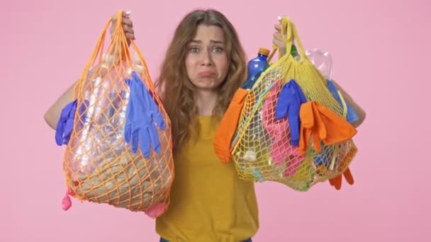 Μια Νεαρή Θλιμμένη Γυναίκα Κρατάει Σακούλες Πλαστικά Απορρίμματα Και Κοιτάζει — Αρχείο Βίντεο