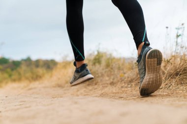 Spor yaparken koşan atletik bir kadının kesilmiş fotoğrafı.