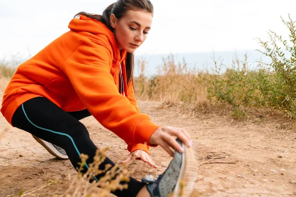 Photo of nice athletic woman using earphones and doing exercise — Stock Photo, Image