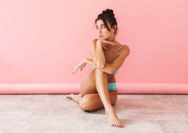 Güzel esmer, genç, zayıf kız bikini giyiyor.