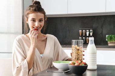 Kafkasyalı, rahat elbiseli, kahvaltı yapan genç bir kadın.