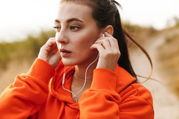 Fénykép gyönyörű sportos nő segítségével fülhallgató edzés közben — Stock Fotó