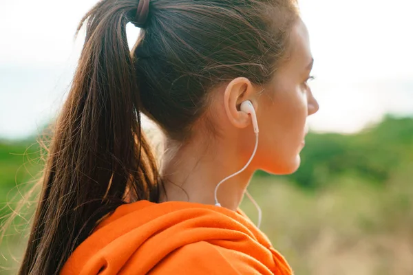 Photo of beautiful athletic woman using earphones while working out — Stock Photo, Image