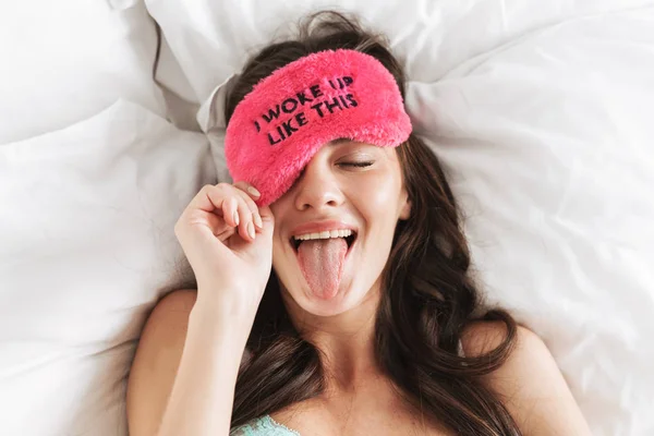 Image of young woman wearing lingerie and sleeping mask lying in — 스톡 사진