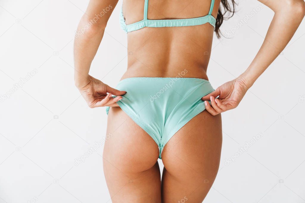 Beautiful young slim girl wearing bikini standing isolated