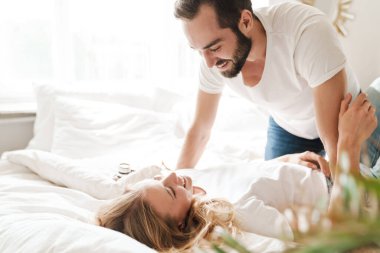 Genç ve mutlu bir çift oturma odasındaki kanepede dinleniyor.