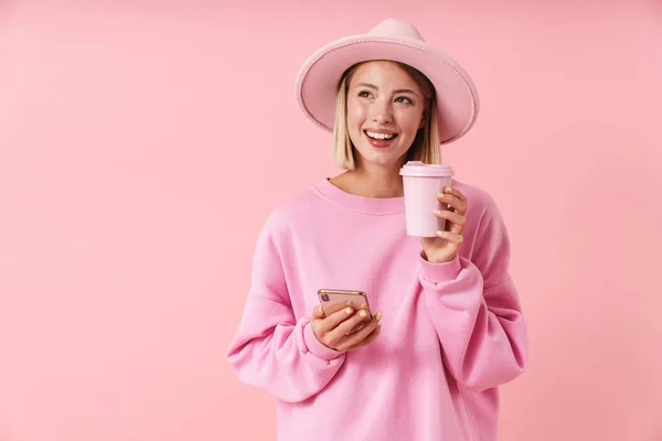 Retrato de mujer hermosa en sombrero sosteniendo teléfono inteligente y taza de café — Foto de Stock