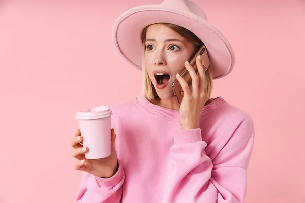 Portrét ženy v klobouku drží šálek kávy, zatímco mluví na smartphone — Stock fotografie
