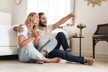 Kanepede oturan neşeli, güzel genç çift.