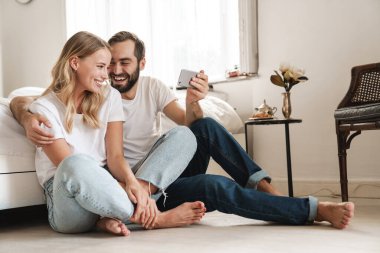 Kanepede oturan neşeli, güzel genç çift.