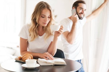 Mutfak masasında kahvaltı eden mutlu genç çift.