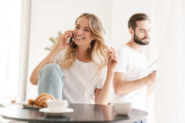 Feliz hermosa pareja joven desayunando en la mesa de la cocina — Foto de Stock