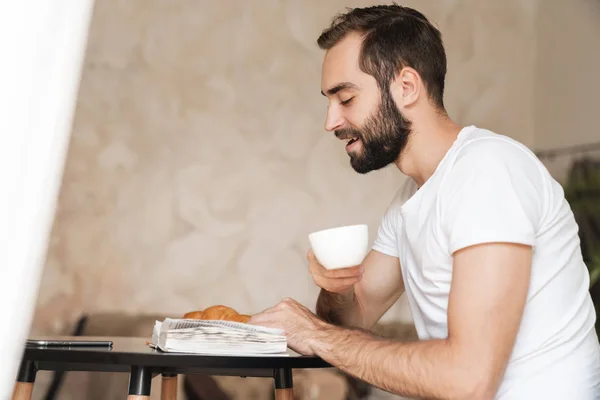 Joven sonriente desayunando en la cocina — Foto de Stock