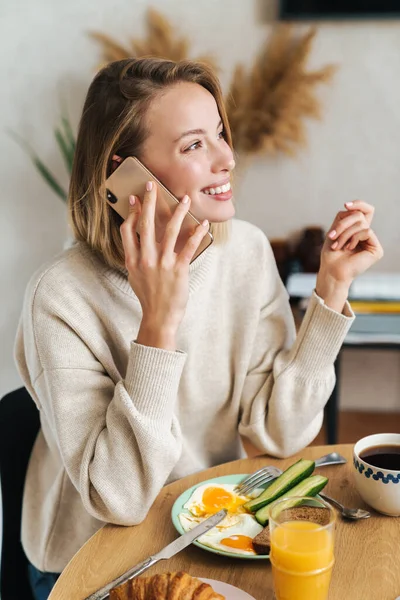 Fénykép elégedett nő beszél mobilon reggeli közben — Stock Fotó