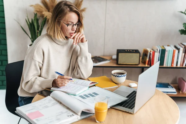 Foto van een vrouw die notities maakt in het oefenboek en laptop gebruikt — Stockfoto