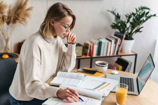 Photo of woman making notes in exercise book and using laptop — 스톡 사진