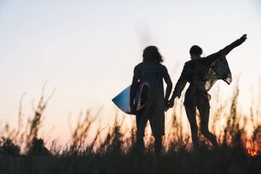 Mutlu genç çift sahilde dururken sarılıyor.