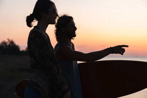 Feliz joven pareja sosteniendo mientras está de pie en la playa —  Fotos de Stock