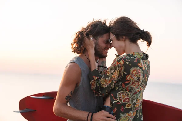 Joyeux jeune couple étreignant tout en se tenant à la plage — Photo