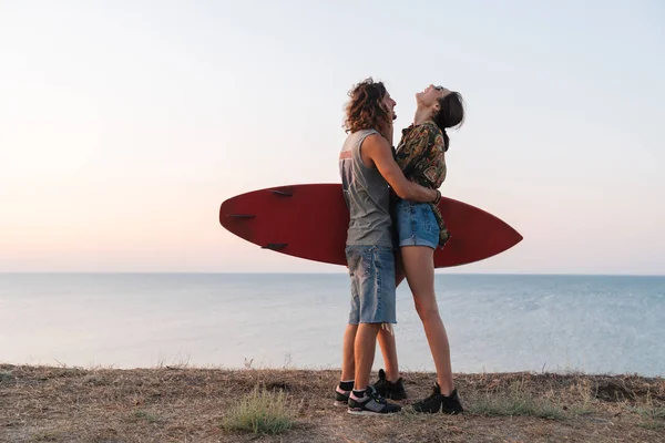 快乐的年轻夫妇站在海滩上拥抱 — 图库照片