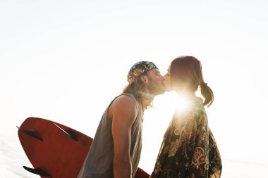 Kafkasyalı romantik çiftin sörf tahtası ve öpüşme fotoğrafları.