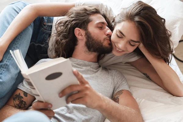 Amour couple à l'intérieur à la maison se trouve lecture livre ensemble . — Photo