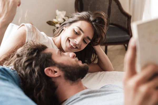 Amour couple à l'intérieur à la maison se trouve lecture livre ensemble . — Photo