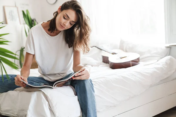 Sorrindo linda menina leitura revista — Fotografia de Stock