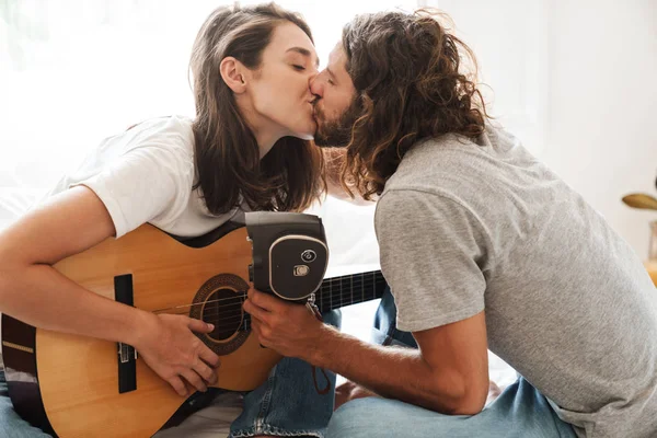 Loving couple indoors at home play on guitar. — 스톡 사진