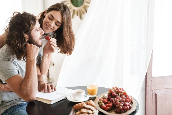 Loving couple indoors at home in kitchen have a breakfast — 스톡 사진