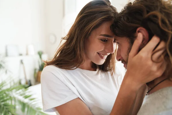 Liebespaar drinnen zu Hause posiert beim Umarmen. — Stockfoto