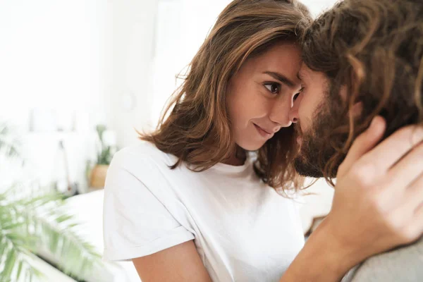 Liebespaar drinnen zu Hause posiert beim Umarmen. — Stockfoto