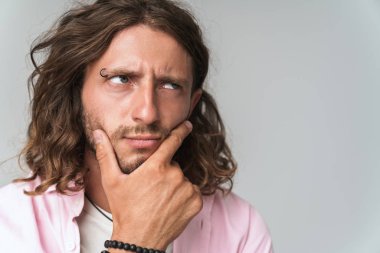 Yakışıklı, düşünceli, sıradan kıyafetler giyen genç adam.