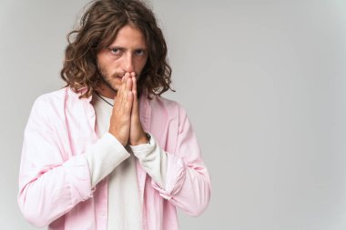 Gri üzerinde tek başına duran konsantre genç adam.