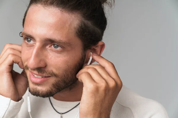 Close up of a smiling young man enjoys listening to music — Stock Photo, Image