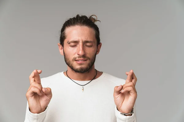 Bezorgde jongeman staat geïsoleerd over grijze achtergrond — Stockfoto