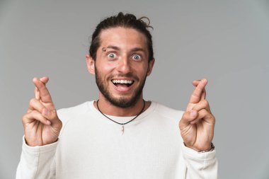 Gri arka planda yalnız duran endişeli genç adam