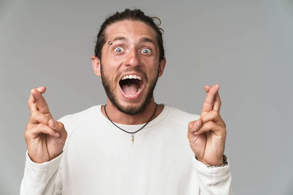 Worried young man standing isolated over gray background — Stock Photo, Image