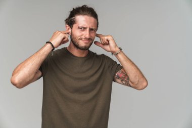 Gri üzerinde yalnız duran sinirli genç adam.