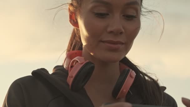 Açık Havada Akıllı Telefondan Oynayan Gülümseyen Güzel Asyalı Spor Kadınının — Stok video