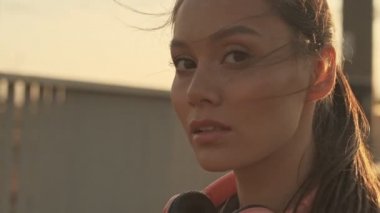 Kapalı alanda dikilirken kameraya bakan güzel Asyalı spor kadını