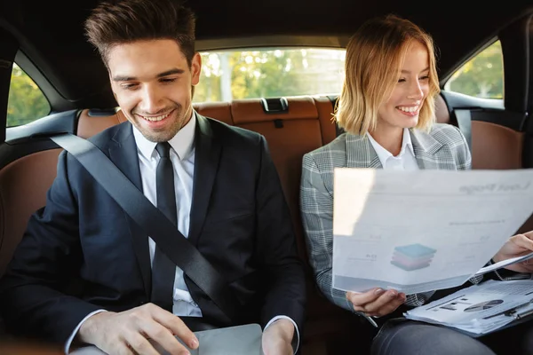 Image of businesslike man and woman sitting in car with working — Stok fotoğraf