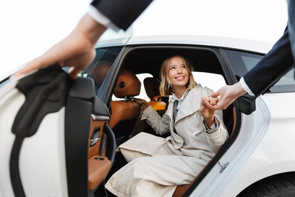 Foto di un uomo gentile che aiuta una bella donna d'affari ad uscire dalla macchina — Foto Stock