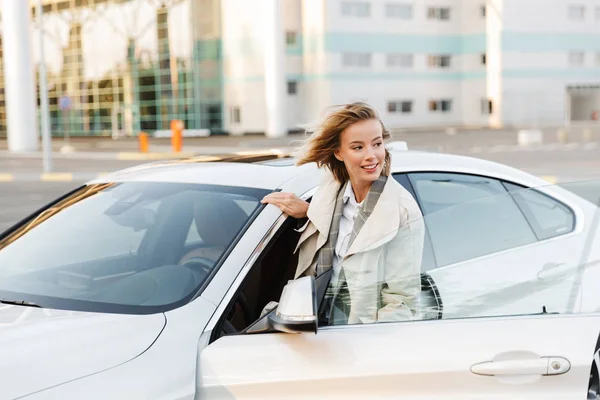 Image of young beautiful business like woman sitting in luxury ca — стоковое фото