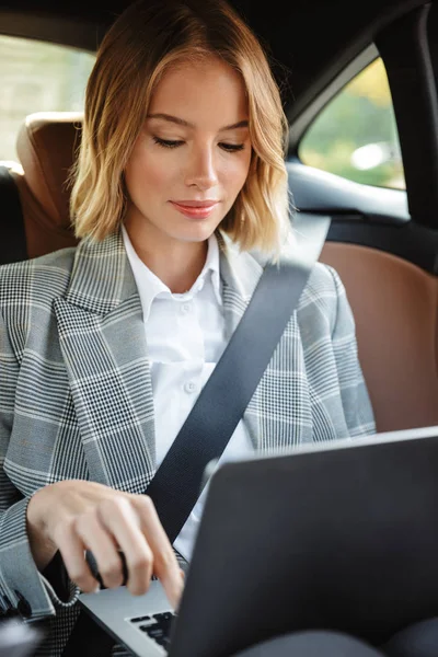 Imagen de la mujer de negocios usando el ordenador portátil dentro del coche en el pasajero — Foto de Stock