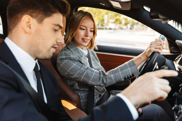 Image of young caucasian businesslike man and woman riding in ca — Stock Photo, Image