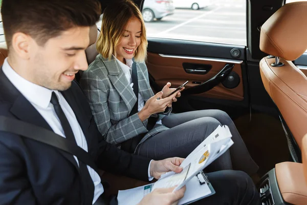 Photo of colleagues man and woman working with documents and cellphone — Stockfoto