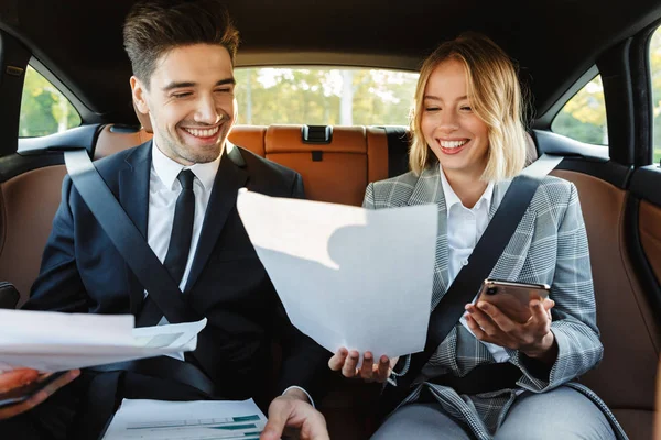 Image of businesslike man and woman sitting in car with working — Stok fotoğraf