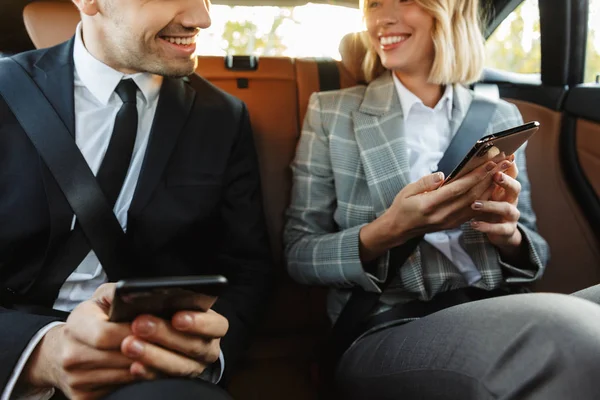 Wizerunek młodego biznesowego mężczyzny i kobiety korzystających ze smartfonów w c — Zdjęcie stockowe