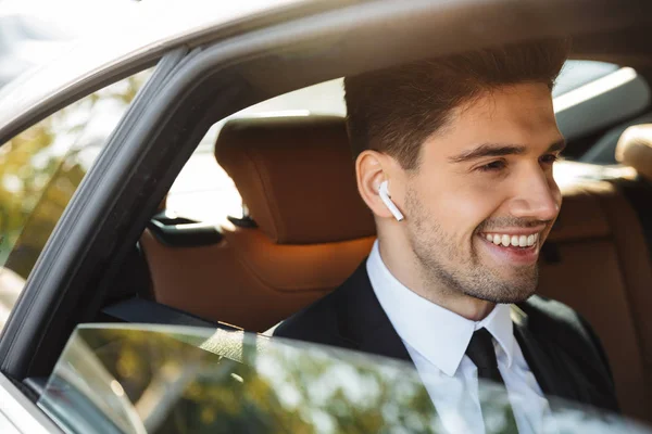 Image of young caucasian businesslike man in suit riding in car — Stok fotoğraf